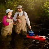 Researchers in a stream collecting data