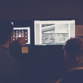 Researcher looking at a microscopic image of a mineral on a screen of a large microscope