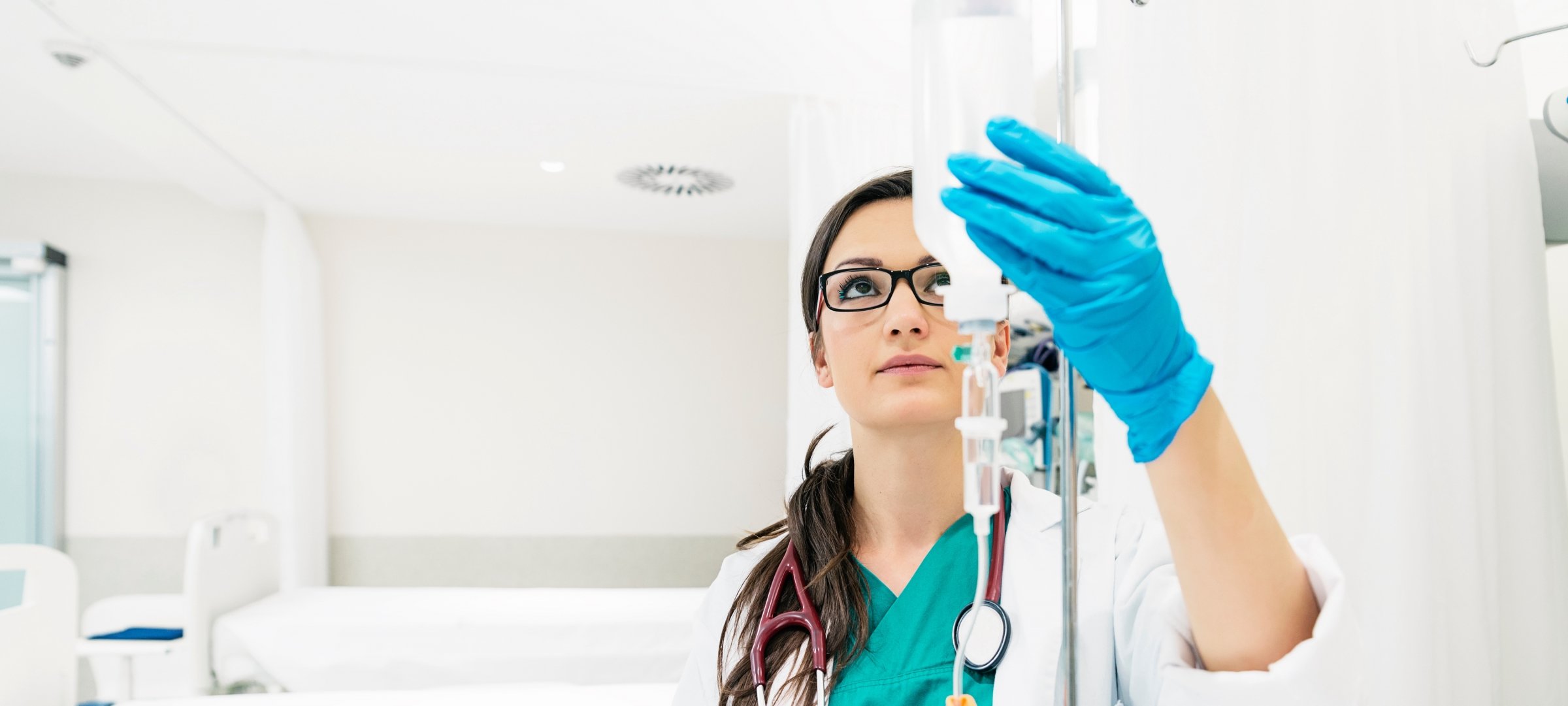 Nurse sets up IV bottle on a rack