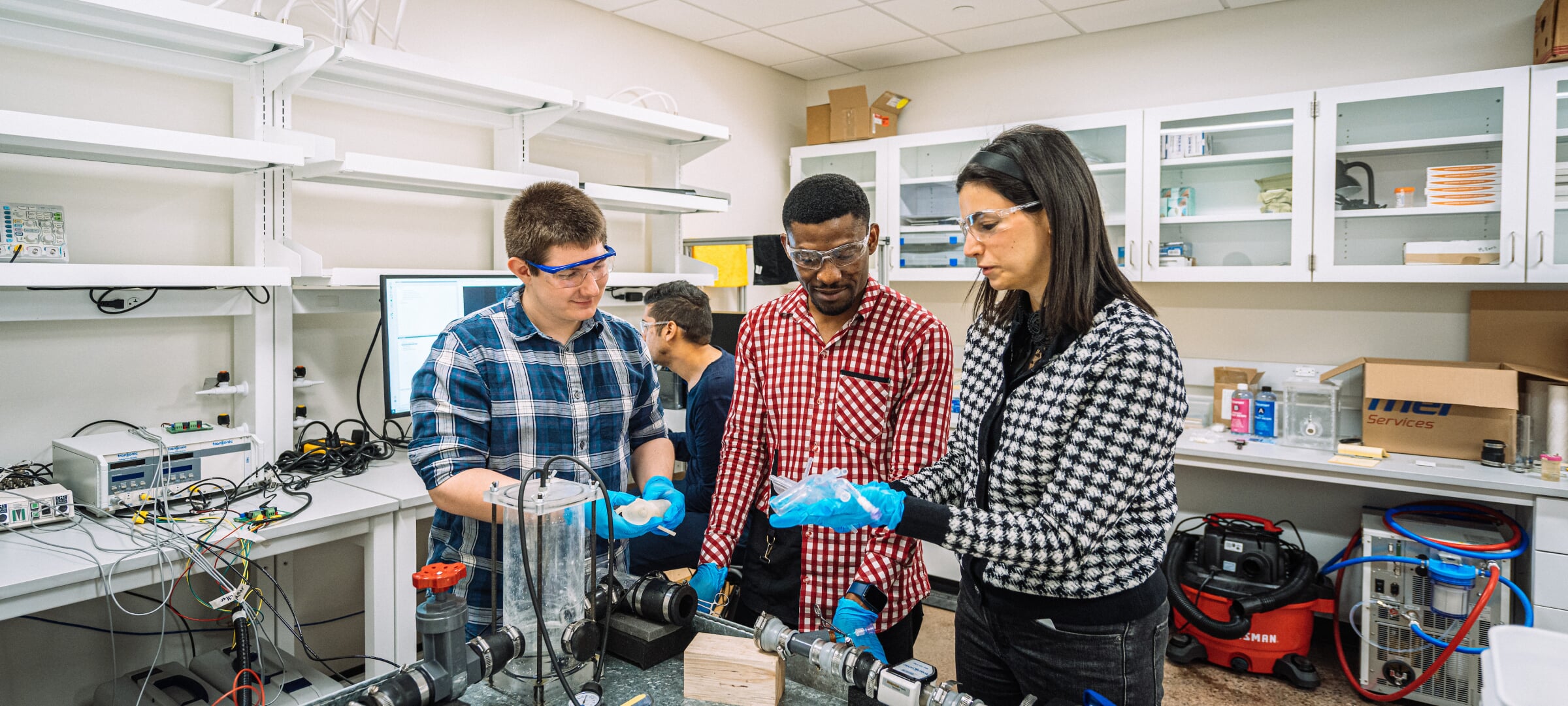 Three people in a lab being shown something