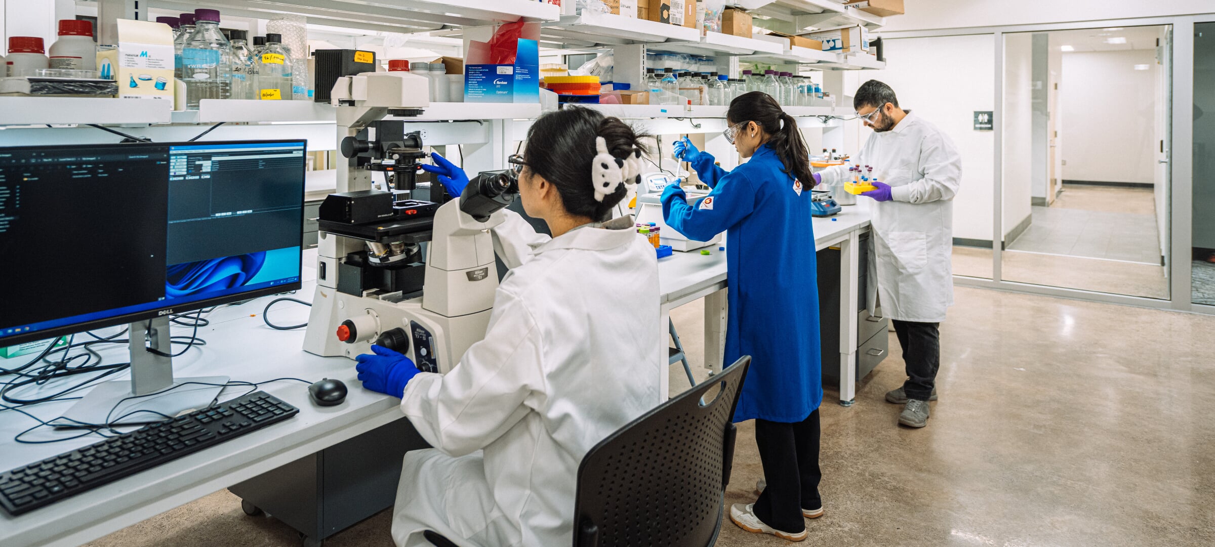 Students in a Lab using a microscope and a pipette