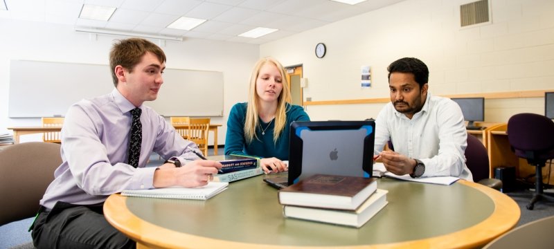 Image of students looking at an open laptop