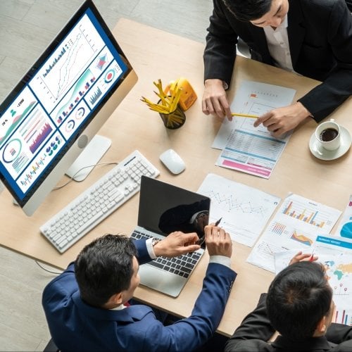 Image of business analytics professionals sitting at a table discussing insights and findings