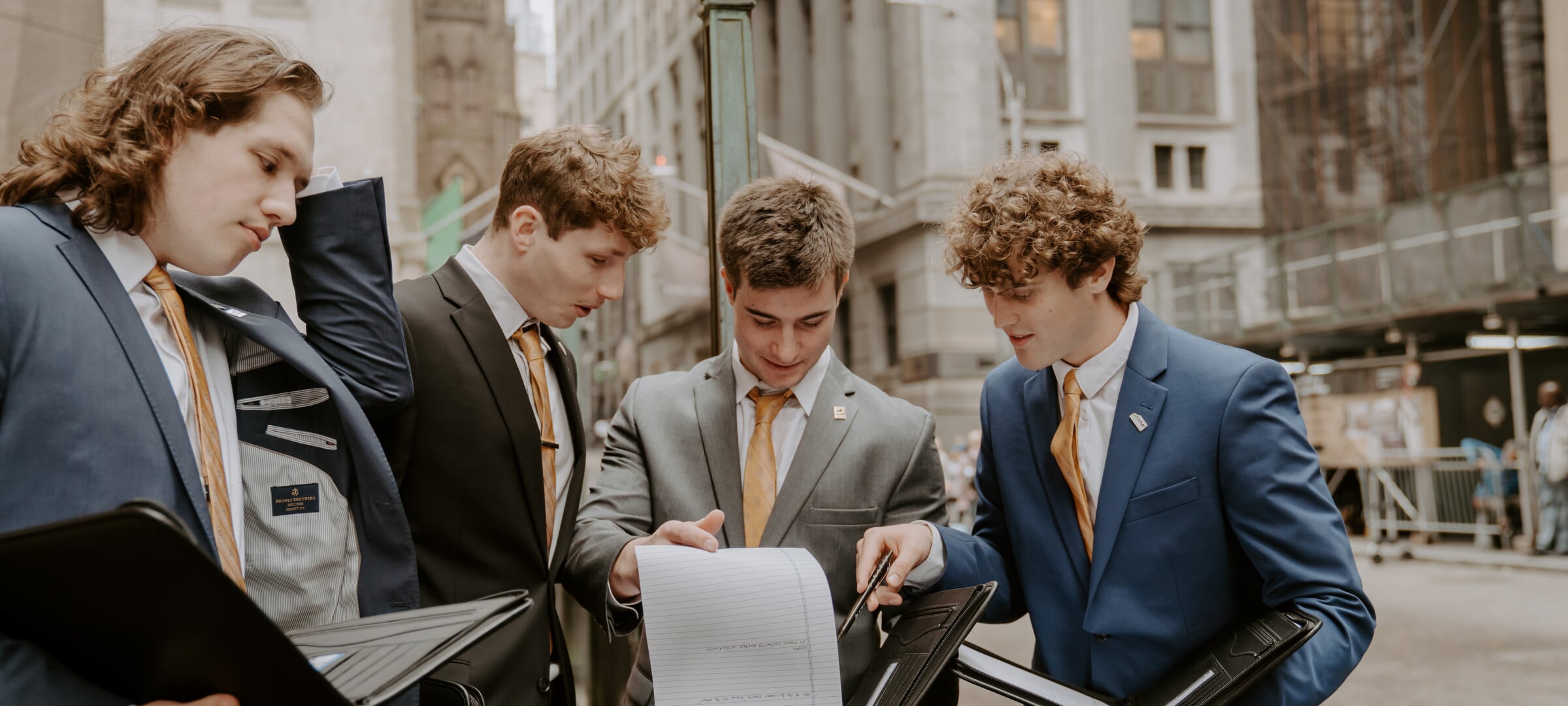 Four business students at Wall Street overlooking data