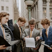 Group of Business students at Wall Street looking over data
