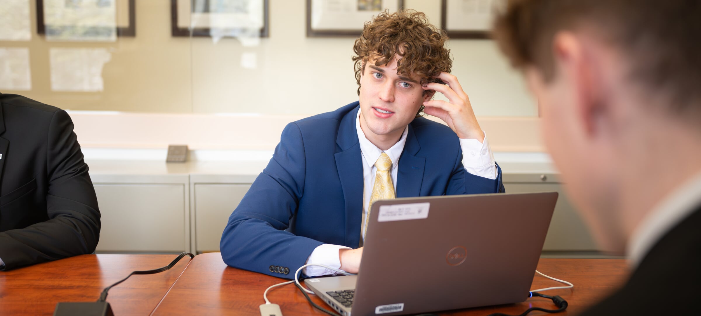 Business students sitting with laptop discussing data.