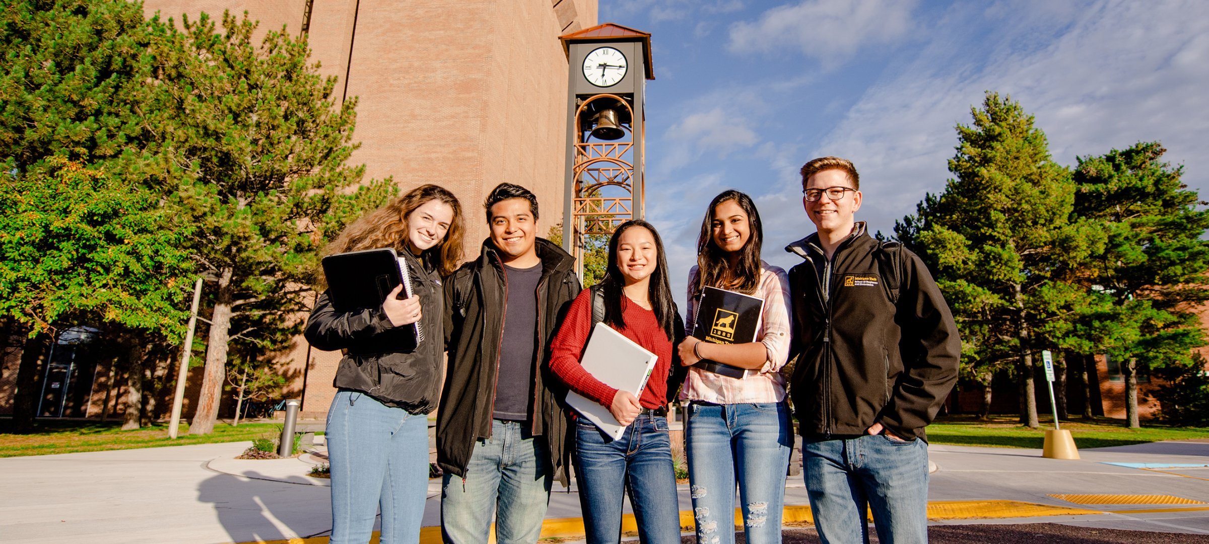 College of Business students on campus in front of the William J. Bernard Jr. Family Clock Tower and the R. L. Smith Building