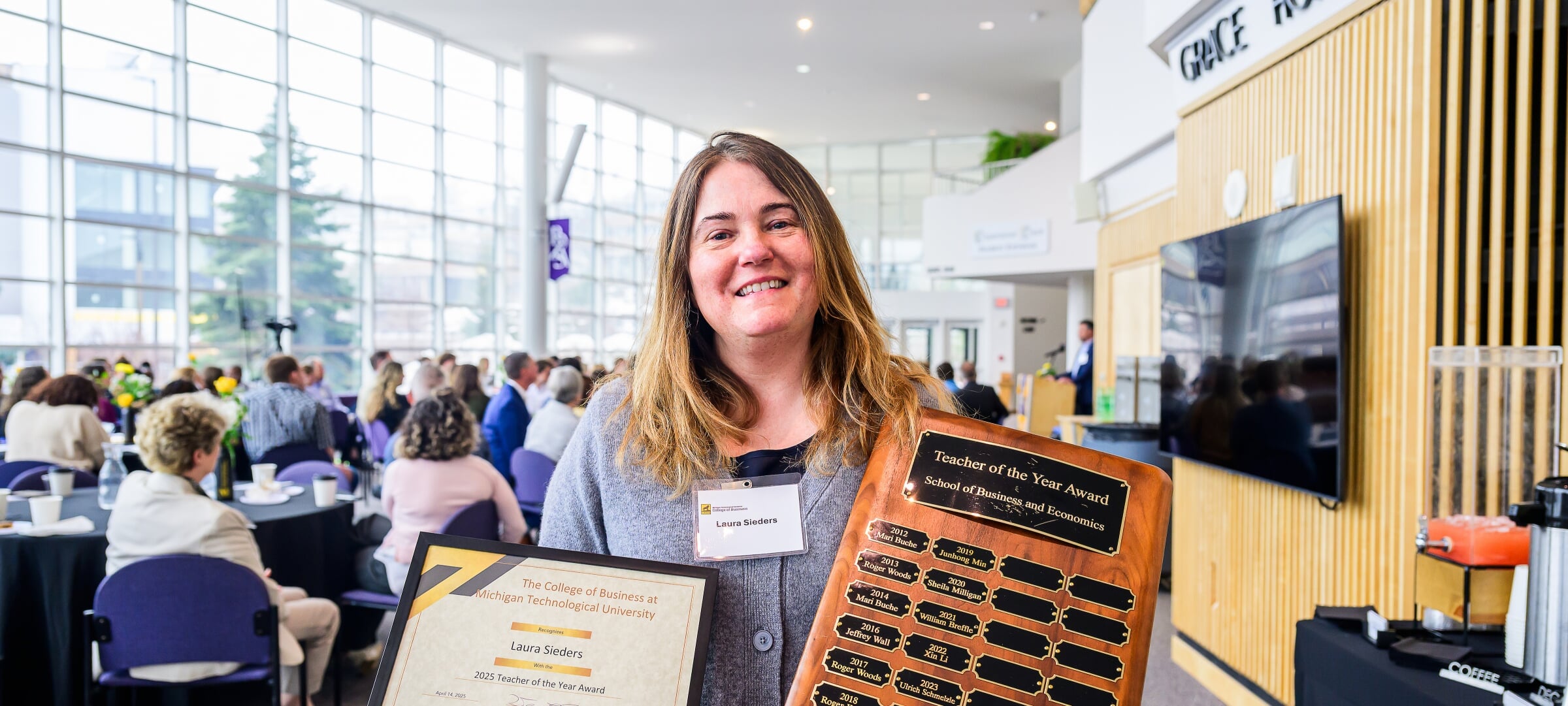 Laura Sieders holding a certificate and a plaque.