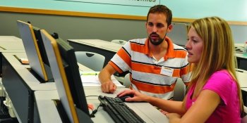 Two people talking at a computer