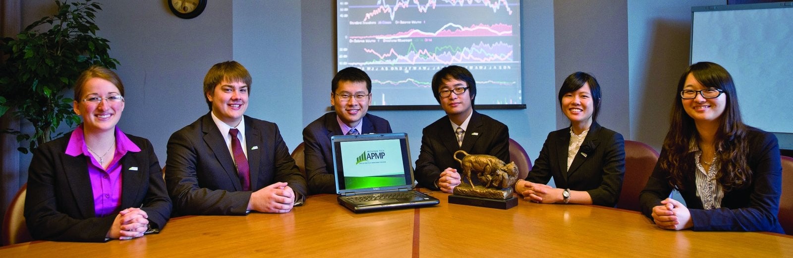 APMP students sitting at a conference table with their trophy.