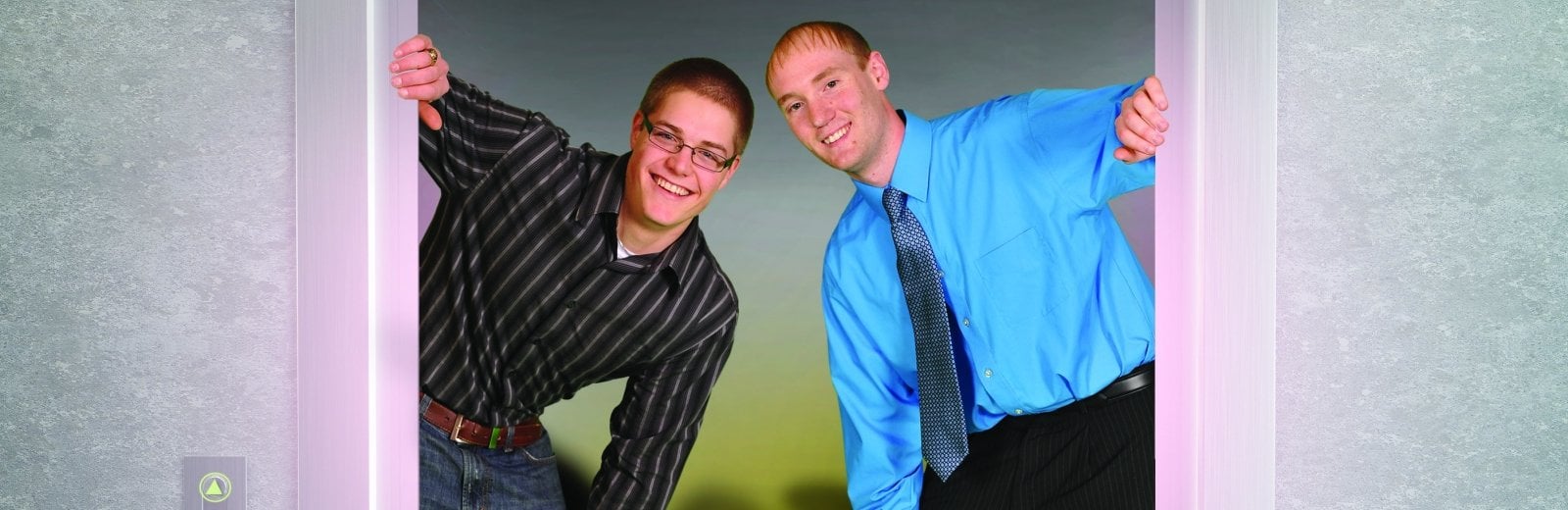 Two student peeking out the door of an elevator