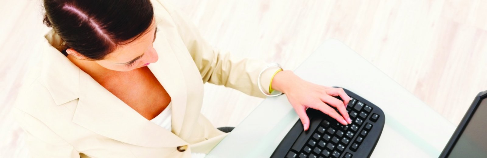 woman at a computer, typing on a keyboard