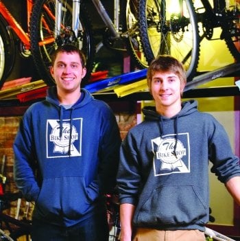 Two men standing in front of racks of bicycles.