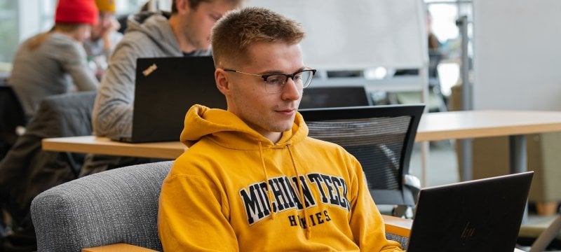 student in library at laptop