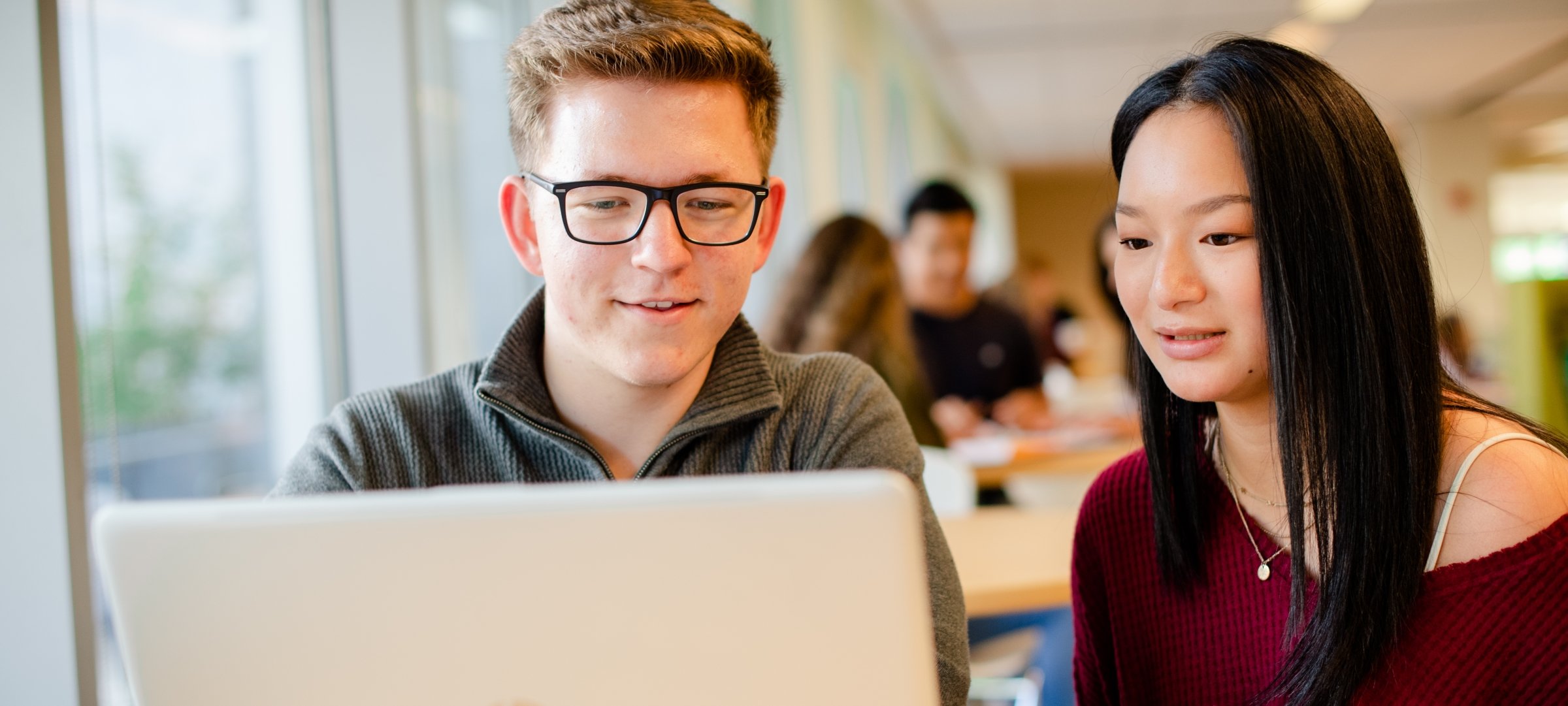 Students working at a table with a laptop.