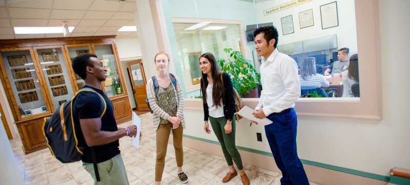 Four students standing in the hallway in the Academic Office Building