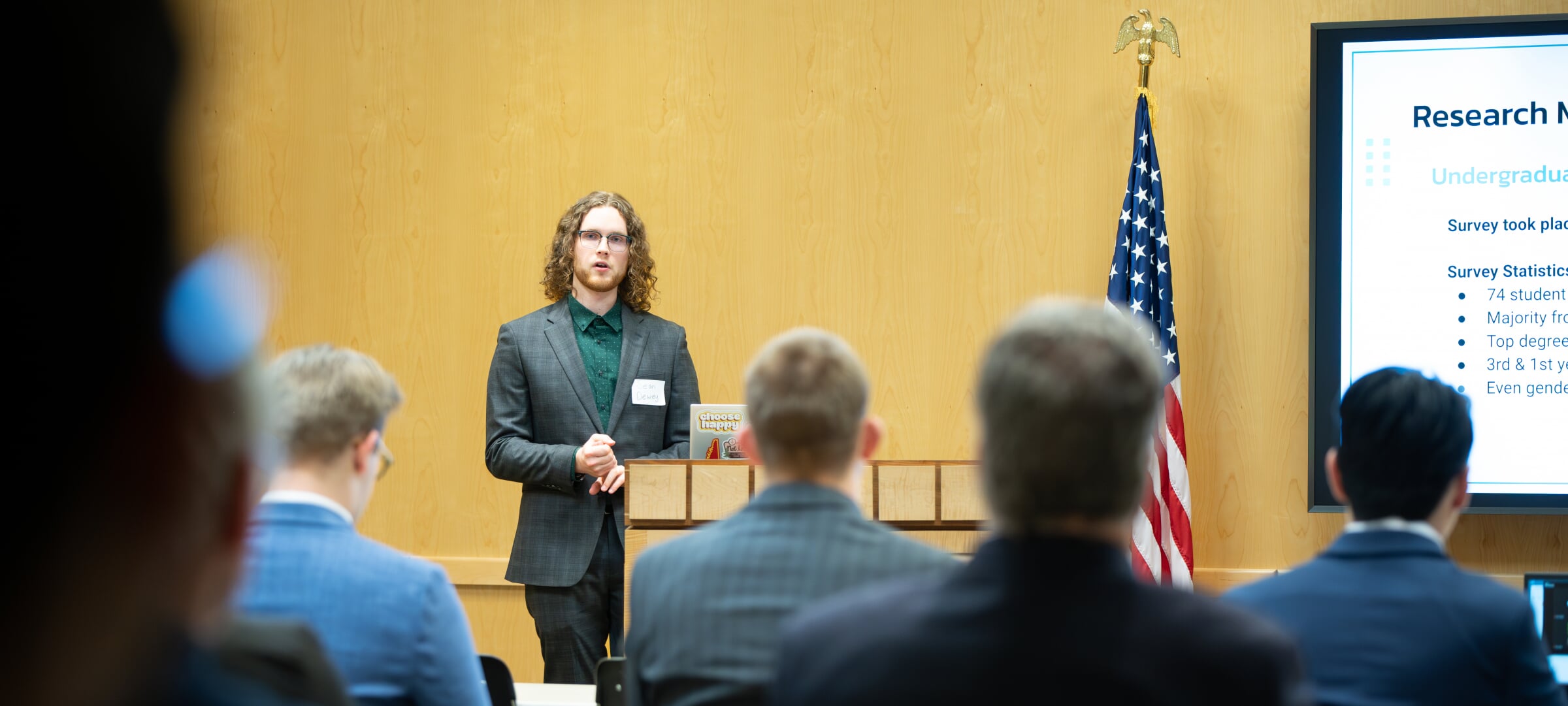 A student in a suit giving a presentation