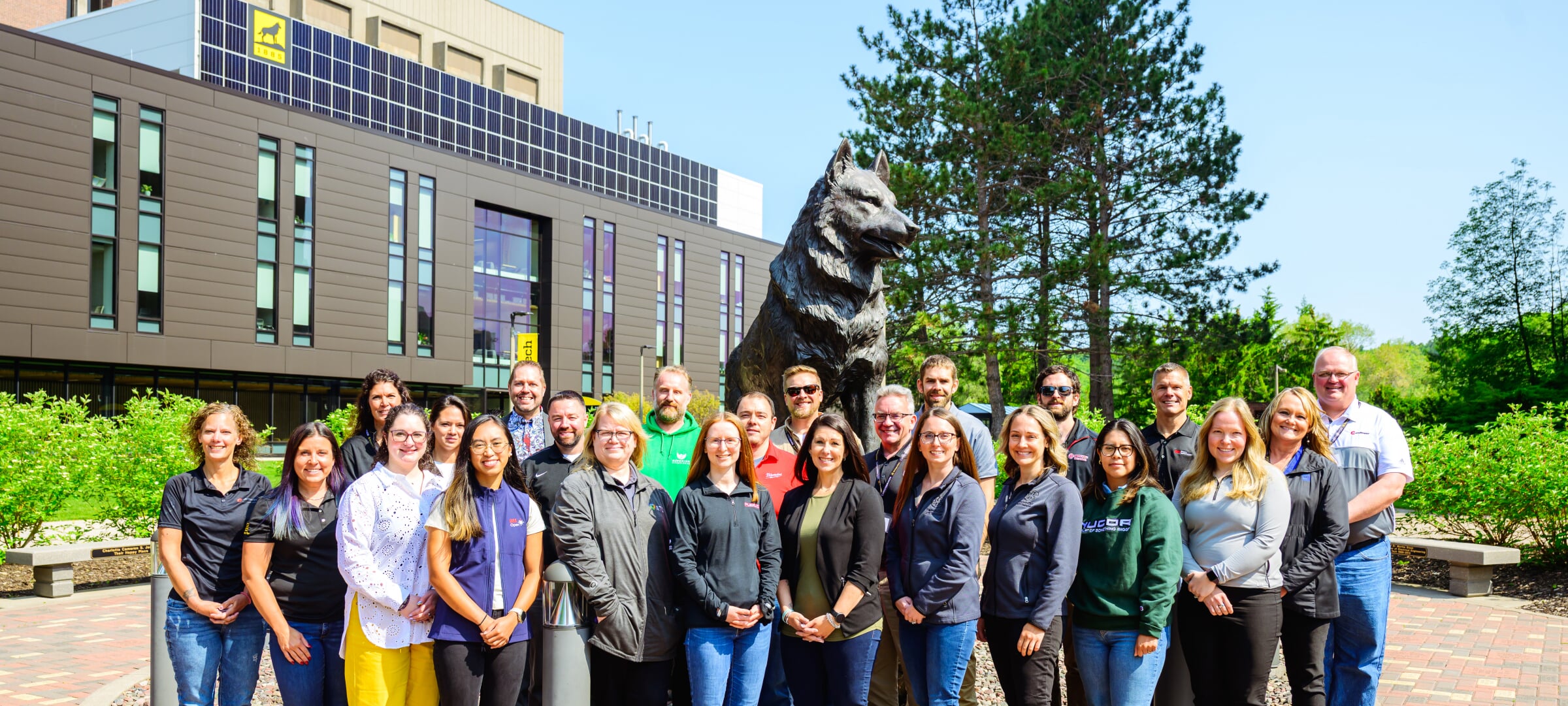Michigan Tech Corporate Advisory Board group photo standing in front of the husky statue outside of the H-Stem building.