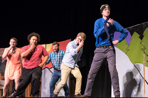 Five students on stage performing a skit.