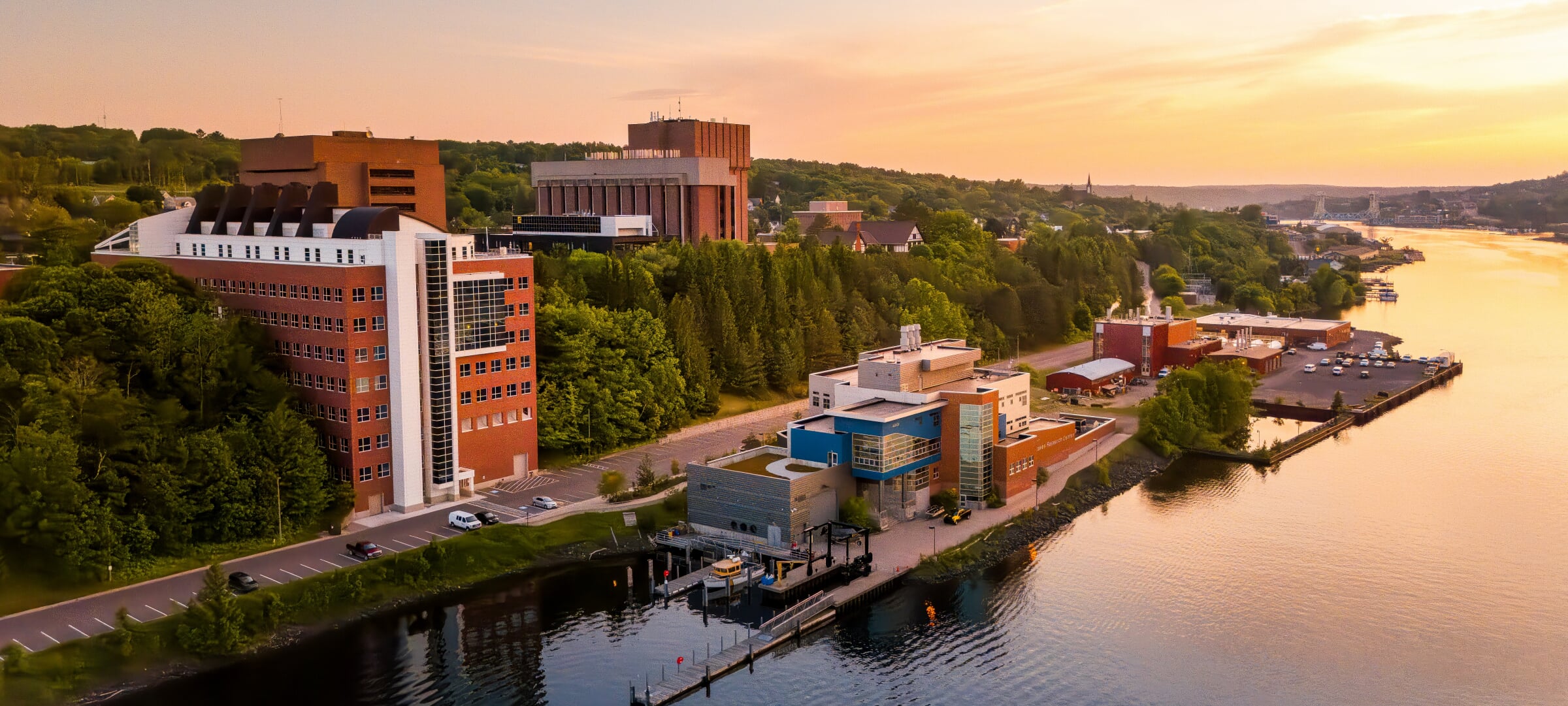 The GLRC building and docks are in the foreground with a beautiful sunset over the portage in the background