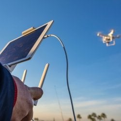 A person controlling a flying drone.