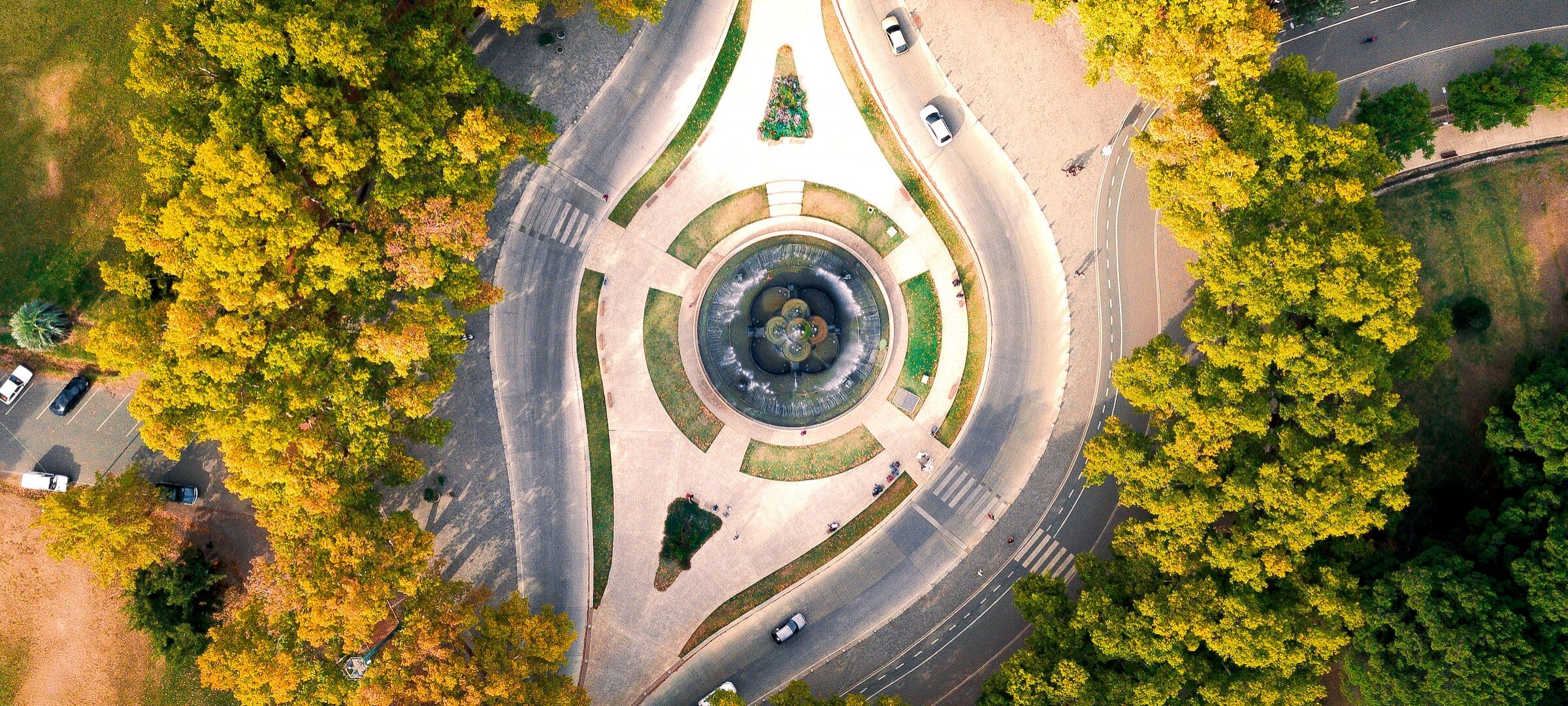 Aerial view of a split road going around a statue