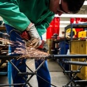 Student welding a piece of the steel bridge
