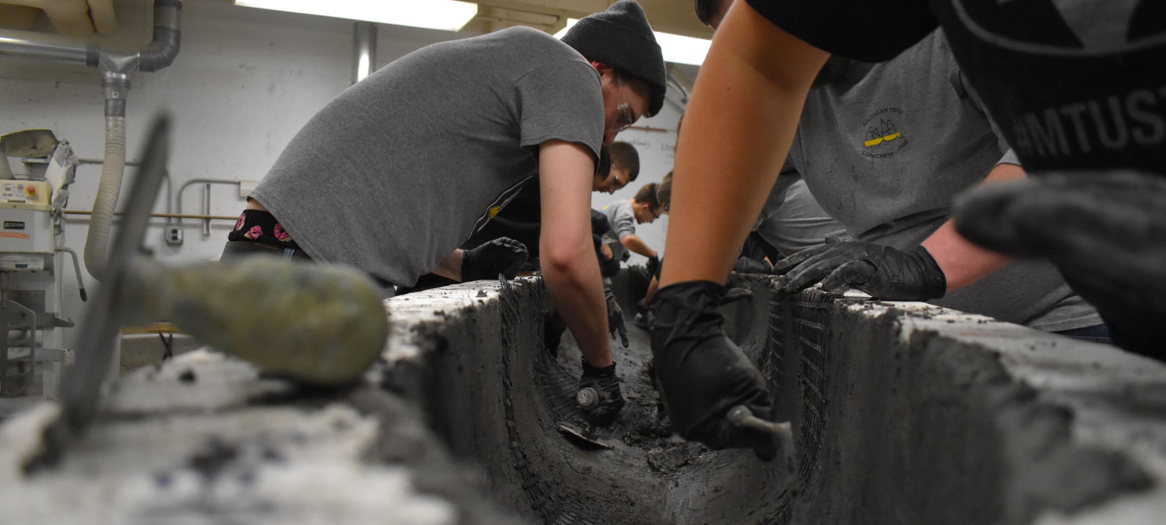 Michigan Tech students apply concrete to the inside of concrete canoe as they prepare for competition.