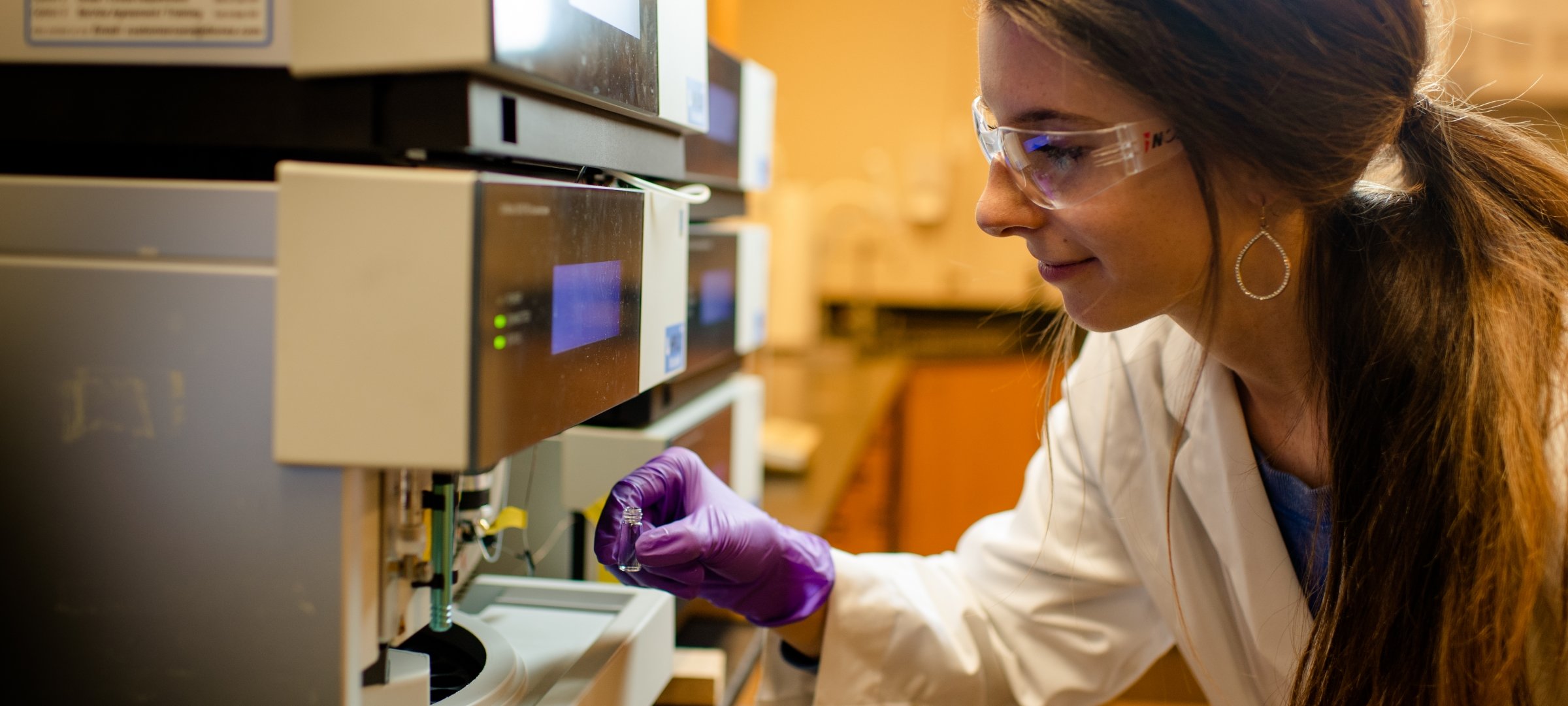 Student putting a water sample into a machine.