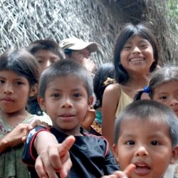 Group of children smiling and pointing at the camera.