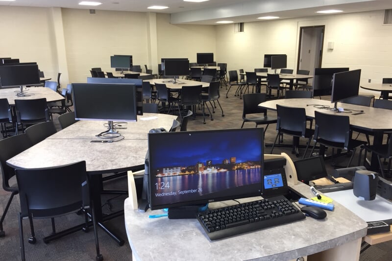 Dillman 208 showing 9 group tables, each with a pair of monitors and surrounded by chairs with casters.