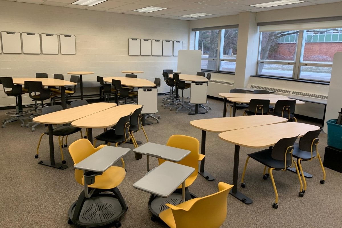Fisher 133 showing a variety of high and low group tables, a group of 3 individual tablet-arm chairs on wheels.