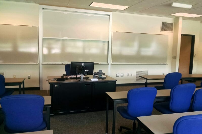 Fischer 325 showing rows of long retangular tables facing a lecture station and whiteboards.