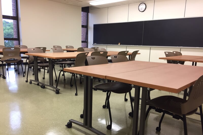 MEEM 405 showing 6 pairs of rectangular tables with 4 chairs each, all with casters, and blackboards along one wall.