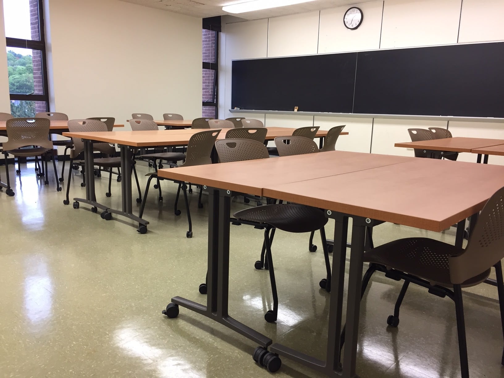 MEEM 405 showing 6 pairs of rectangular tables with 4 chairs each, all with casters, and blackboards along one wall.