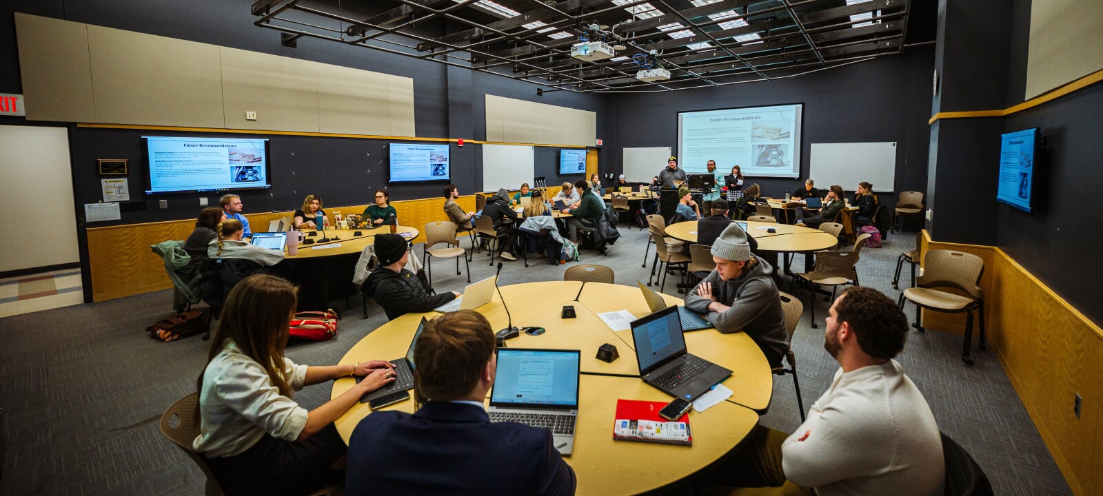 Students sitting at round tables in an active learning classroom.
