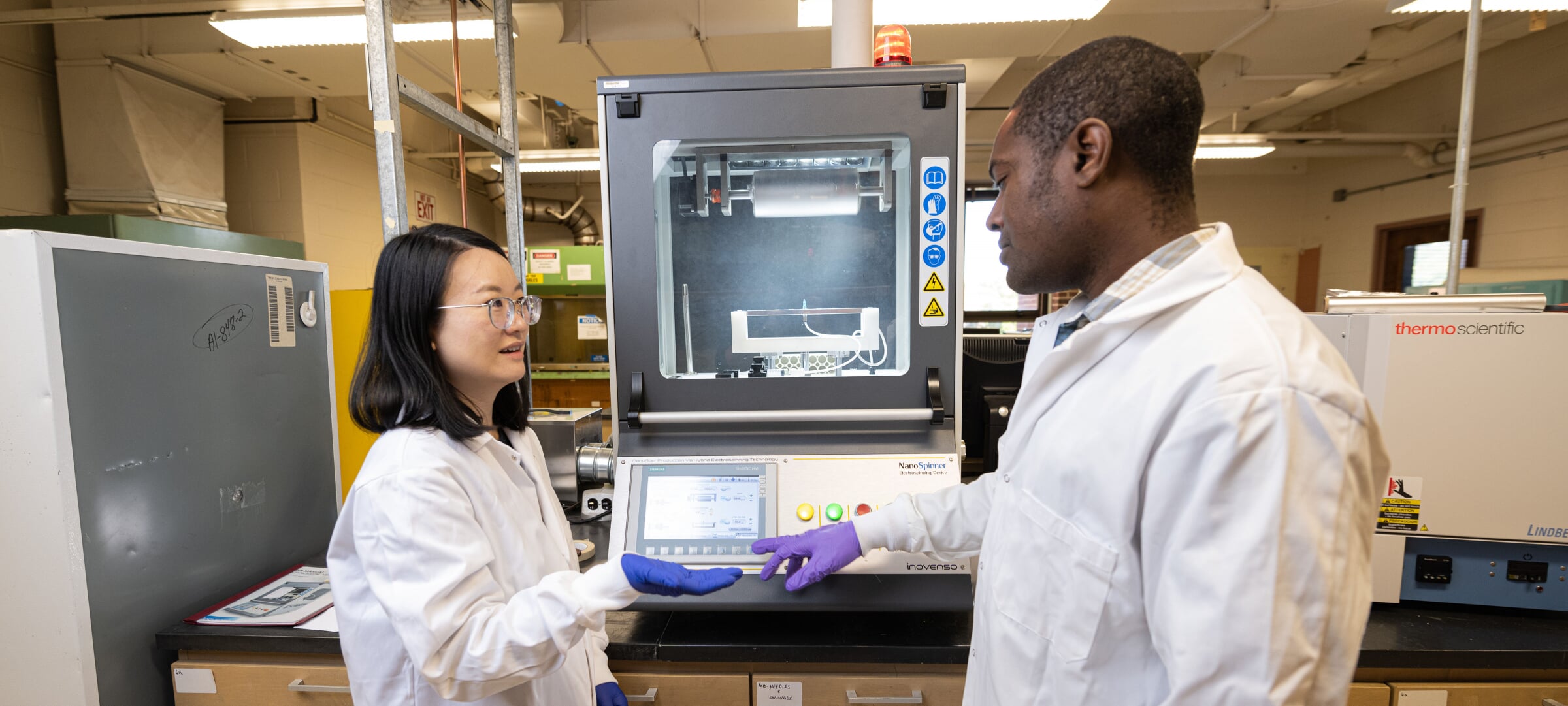 A student consults with faculty about chemistry lab equipment