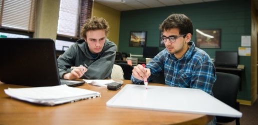 Students writing on a whiteboard in the Chemistry Learning Center.