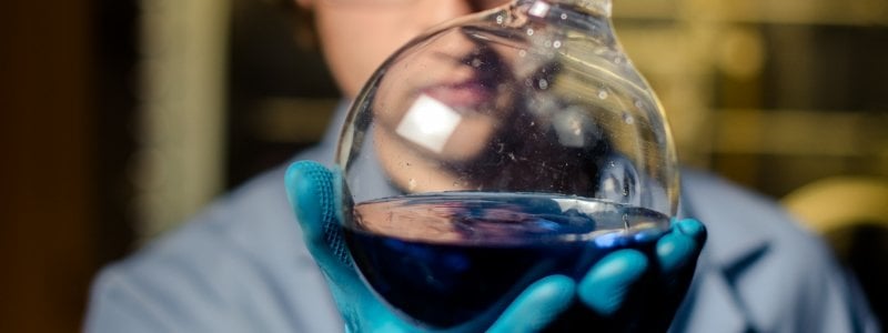 Student holding flask of blue liquid