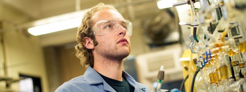 Student looking at chemistry equipment stored against wall