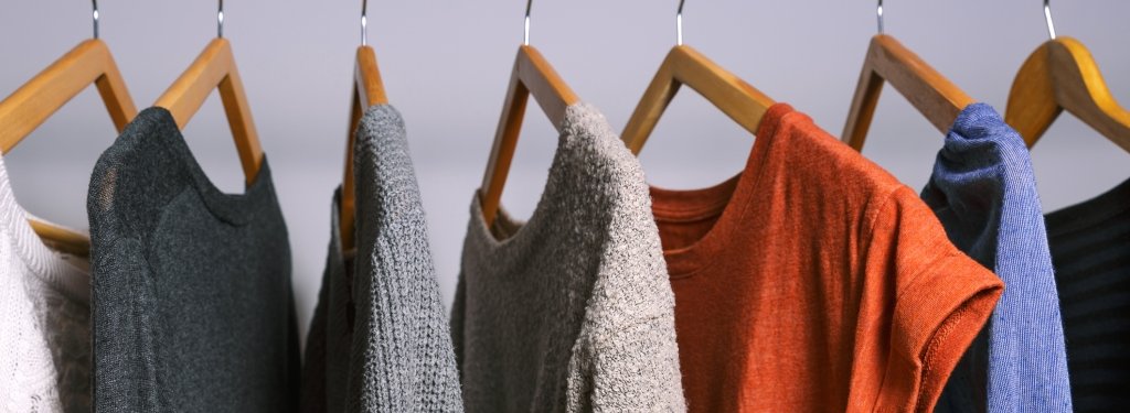 Sweaters and shirts on wooden hangers