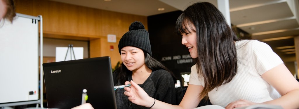 Two students working on a laptop computer.