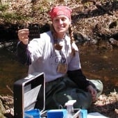 Student at a dig site holding up an artifact.