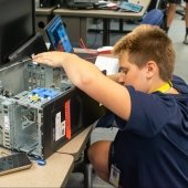 A youth works on a computer in a cybersecurity outreach class