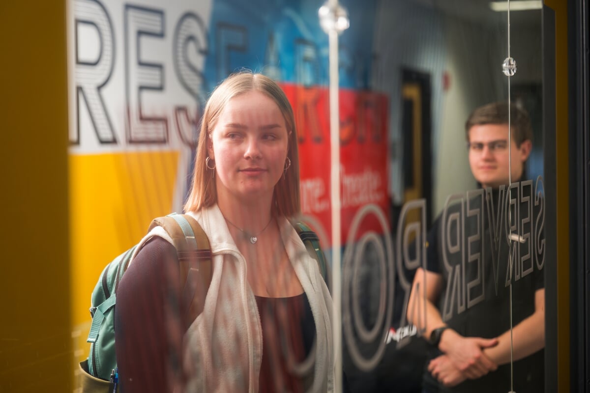 Two students standing in the College of Computing hallway.
