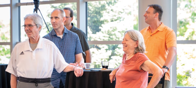 Linda Ott standing with several people around a table.