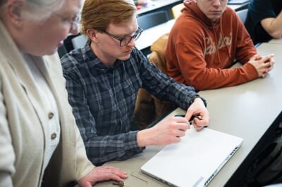 Instructor Walters watching a student pick a lock.