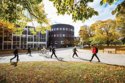 Students walking on campus in front of Fisher and Rekhi Halls on a fall day.