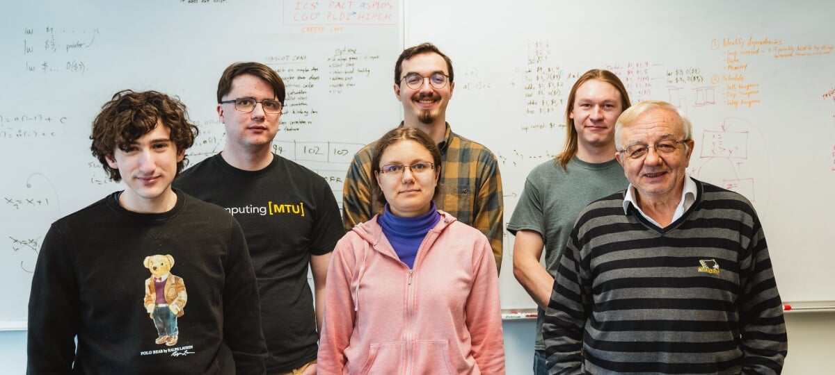 Soner ONder standing with his five graduate students in front of a whiteboard.
