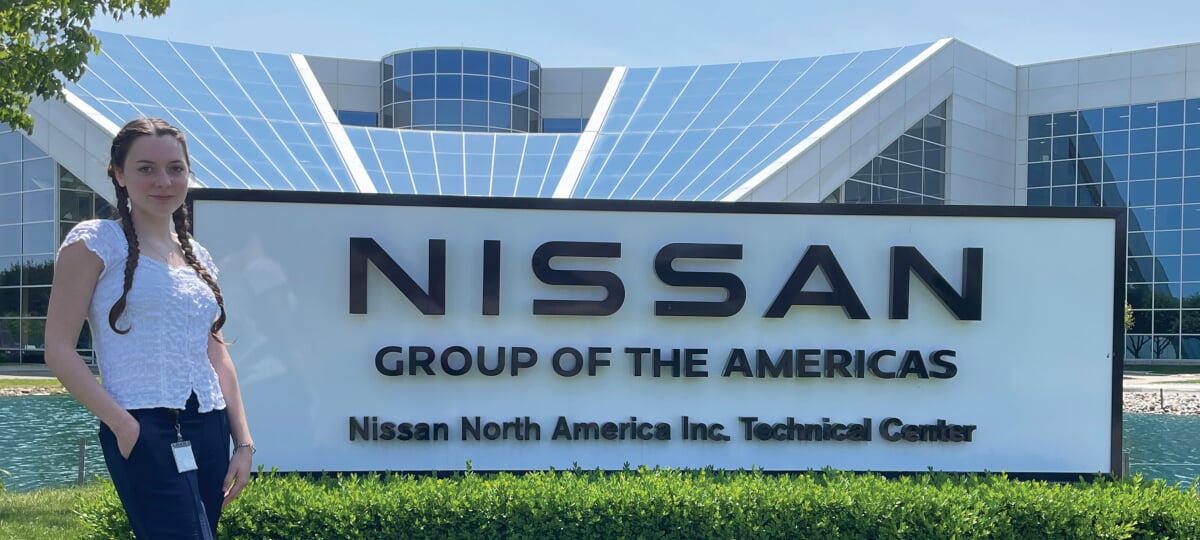 Ashley Baird standing in front of a Nissan Group of the Americas sign.